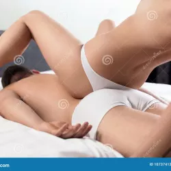 Couple Doing Erotic Massage in Bedroom. Stock Photo